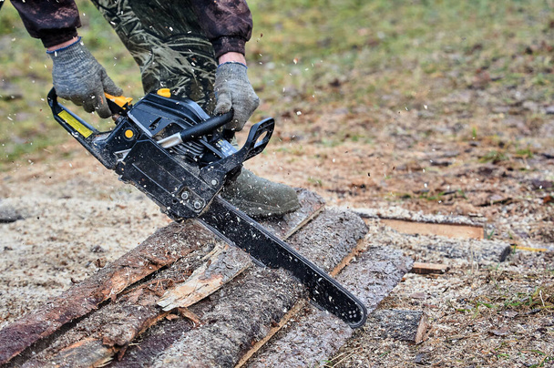 una motosierra se utiliza para cortar madera al aire libre - Foto, Imagen