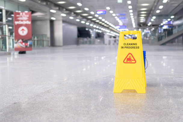 yellow plastic cone with sign showing warning of wet floor in restaurant in department store - Photo, Image