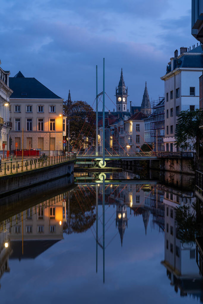En el hermoso Gante en Bélgica a lo largo del río Leie, se encuentra esta hermosa torre del Post con un puente oscilante en primer plano - Foto, imagen