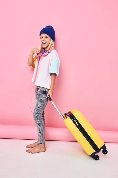 funny girl with robot suitcase vacation pink background - Фото, изображение