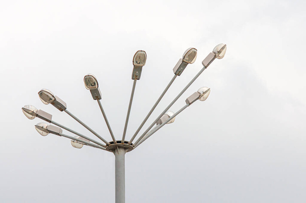 Уличная лампа в виде лучей, на шпиле, на фоне монохромного неба - Фото, изображение