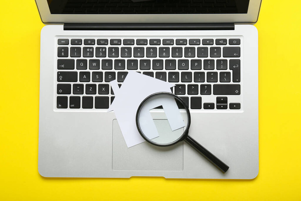 Laptop com casa de papel e lupa sobre fundo amarelo - Foto, Imagem