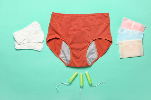 Period panties, pads and tampons on color background - 写真・画像
