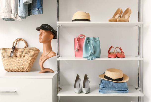 Mannequin avec capuchon en cuir, chaussures élégantes et accessoires sur étagères en boutique - Photo, image
