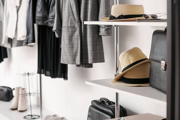 Stylish straw hats on shelves in boutique - 写真・画像