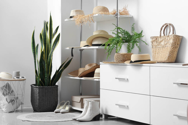 Різні капелюхи, взуття та сумка на полицях в гардеробі
 - Фото, зображення