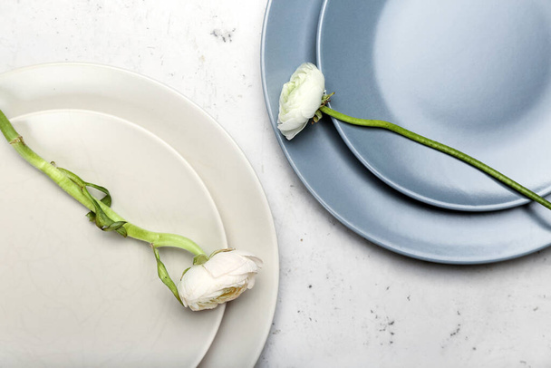 Simple table setting and ranunculus flowers on light background - Foto, afbeelding