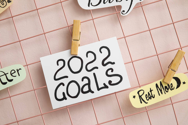 Moodboard mit Figur 2022 und Ziele auf Papierblättern auf farbigem Hintergrund geschrieben, Nahaufnahme - Foto, Bild