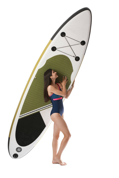 Sportieve jonge vrouw met boord voor sup surfen op witte achtergrond - Foto, afbeelding