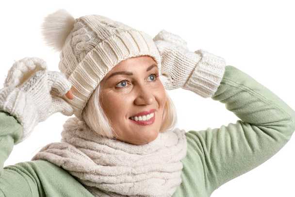 Femme mûre souriante portant un chapeau tricoté sur fond blanc - Photo, image