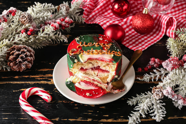 Piatto con gustosa torta bento e decorazioni natalizie su sfondo di legno scuro - Foto, immagini