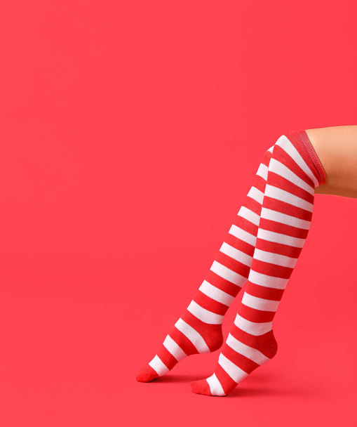 Jambes de jeune femme sexy en bas de Noël sur fond de couleur - Photo, image