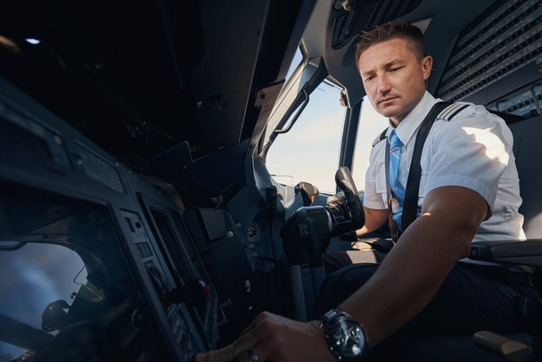 Second pilot pressing switch from his seat in cockpit - Fotografie, Obrázek