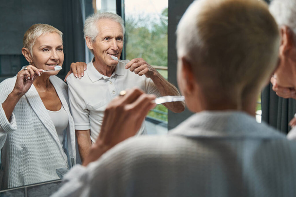 Pozitivní nadšení starší pár čištění zubů - Fotografie, Obrázek