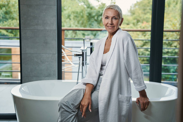 Positive delighted woman sitting on the bath - Fotografie, Obrázek