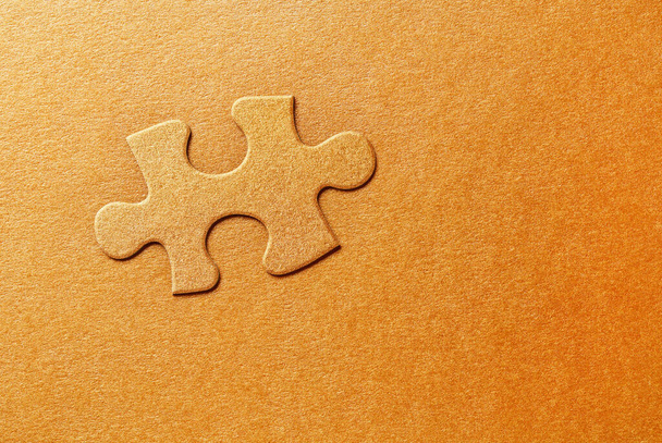 Embossed puzzle piece on golden background - Photo, Image