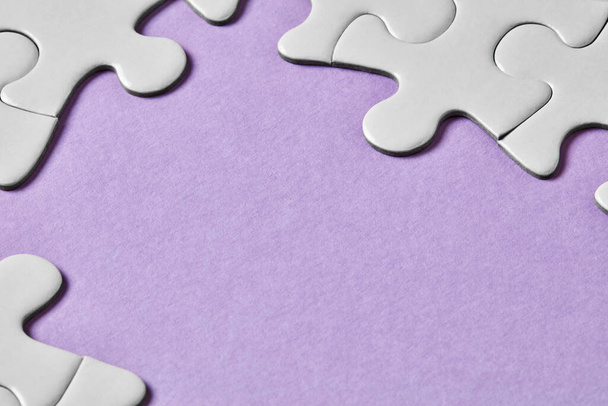Puzzle pieces on purple background - Photo, Image