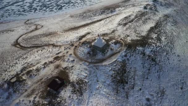 Aerial overhead view. Man walk around white buddhist stupa on top of snowy hill - Footage, Video