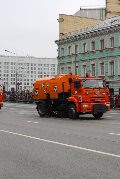 MOSCA RUSSA. Dopo la parata, i camion KAMAZ arancioni nei palloni da calcio puliscono la strada. L'iscrizione sul bordo è "l'arte delle strade bene-effettuate". Il nono di maggio. - Foto, immagini