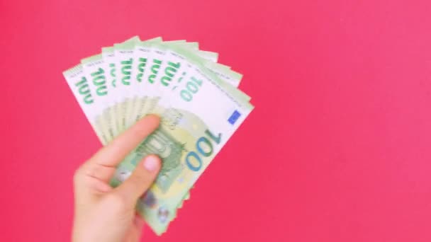 Ruku v ruce drží EURO bankovky na růžovém pozadí barvy. Počítám 100 eurobankovek v hotovosti. Úspora Eu měna Euro výměna Bohatství koncept Online kasino vítěz Úspěšné obchodní obchodování - Záběry, video