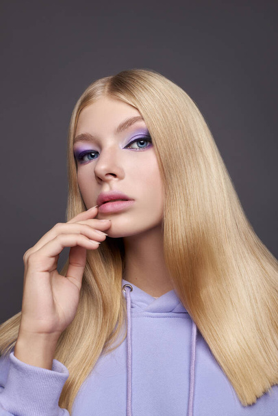 Beauty portrait young woman, purple lilac makeup on eyes girl. Professional face makeup, long smooth blonde hair - Foto, immagini