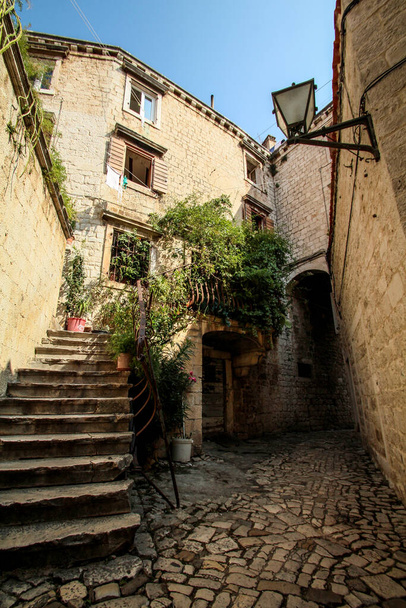 Scenic narrow, typical mediterranean alley in downtown Trogir, Croatia - Zdjęcie, obraz