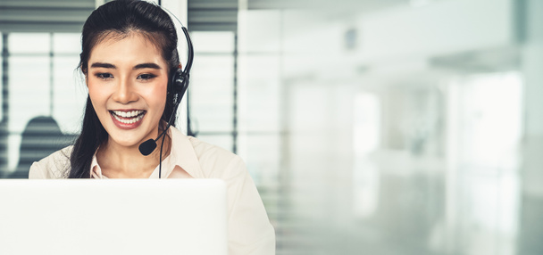 Businesswoman wearing headset working actively in office - Photo, image