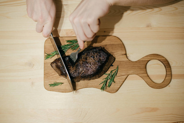 the chef cuts the steak with a large knife  - Foto, imagen