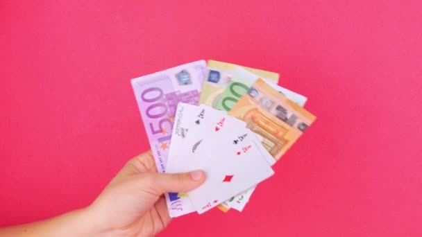 Cinco de una clase de cartas de Poker Game en mano de jugador con billetes de dinero en euros fondo rosa. Suerte combinación de ases Joker revealing.Online juego de casino Ganador de apuestas de éxito concepto Entretenimiento 4K - Metraje, vídeo