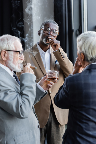 elderly successful business partners smoking cigars and drinking whiskey in office - Photo, Image