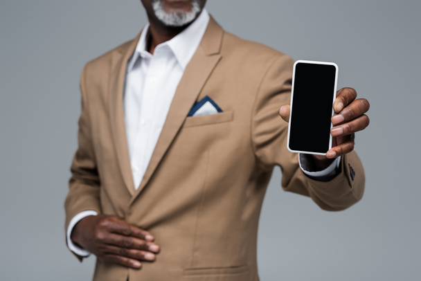 Beyaz ekran gri üzerine izole edilmiş akıllı telefon gösteren Afrika kökenli Amerikalı iş adamı görüntüsü. - Fotoğraf, Görsel