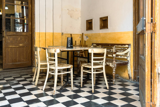 Жирона, Испания - 6 декабря 2021 года. Старый ресторан с ржавыми столами и стульями. - Фото, изображение