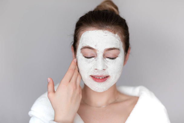 beautiful woman doing Cosmetology and professional skin care with clay mask - Photo, Image