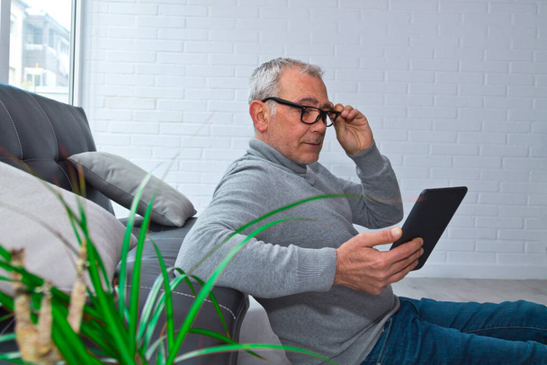 Happy relaxed man using his digital tablet - Photo, Image
