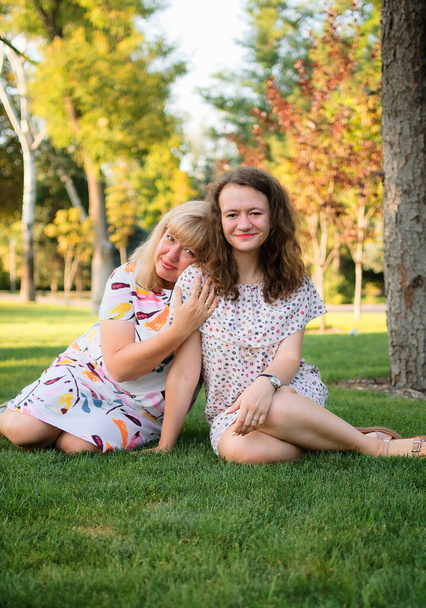 Žena portrét krásné plus velikost blond, modrooké matky a dcery v parku během léta. Rodinný den, koncept spokojených lidí - Fotografie, Obrázek