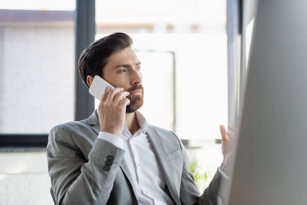 Businessman in formal wear talking on smartphone in office  - Foto, Imagem