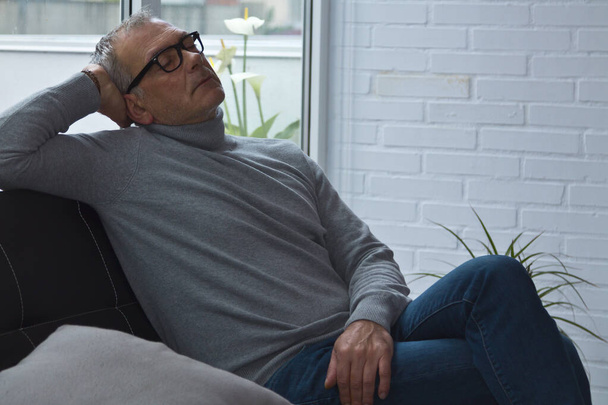 mature man relaxed on the sofa at home - Photo, Image