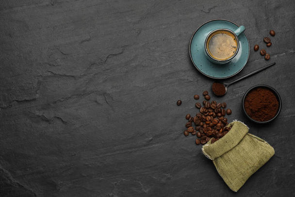 Flat lay composition with coffee grounds and roasted beans on black background, space for text - Фото, зображення