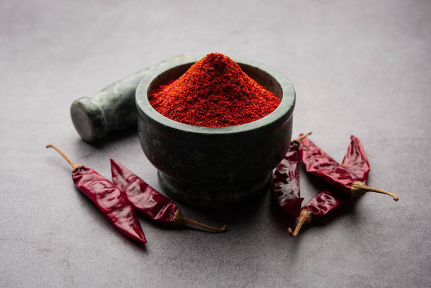 Red Chilli or Lal Mirchi or mirch with Powder in a bowl or mortar over moody background, selective focus - 写真・画像