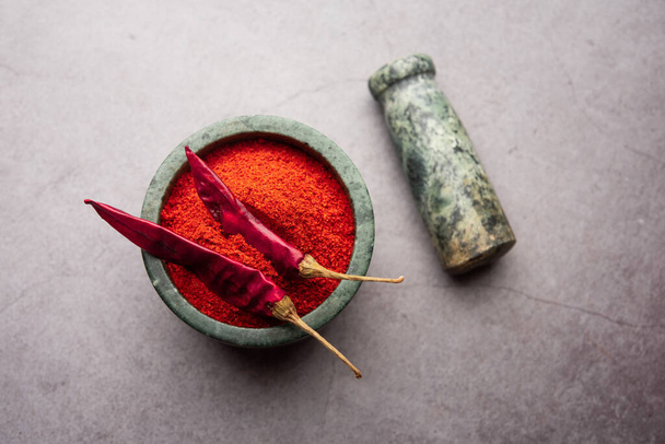 Red Chilli or Lal Mirchi or mirch with Powder in a bowl or mortar over moody background, selective focus - Fotó, kép