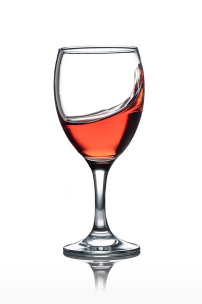Μετακίνηση κόκκινο ποτήρι κρασί απομονωμένο από το λευκό φόντο - Φωτογραφία, εικόνα