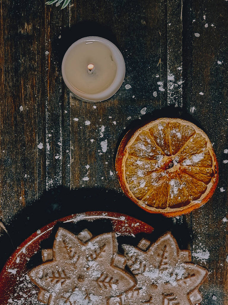 christmas wooden background with cookies oranges fir branches and cones - Foto, afbeelding