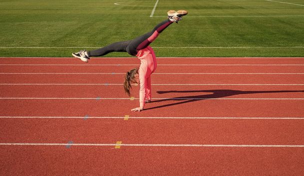 healthy child girl training fitness on stadium running track, gymnastics - 写真・画像