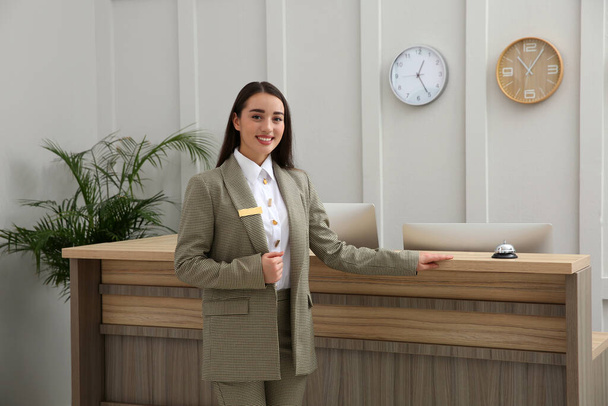 Portrait of beautiful receptionist near counter in hotel - Foto, imagen
