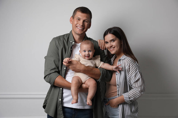 Happy family. Couple with their cute baby near light wall - Foto, Imagem