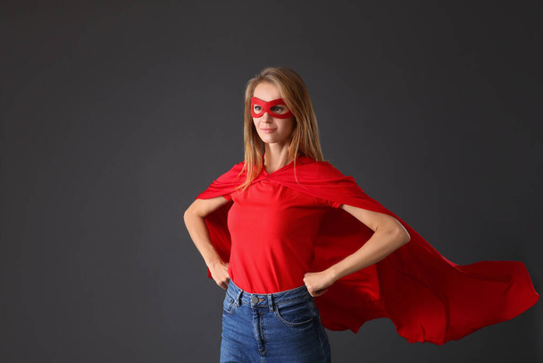 Confident woman wearing superhero cape and mask on grey background - Foto, afbeelding