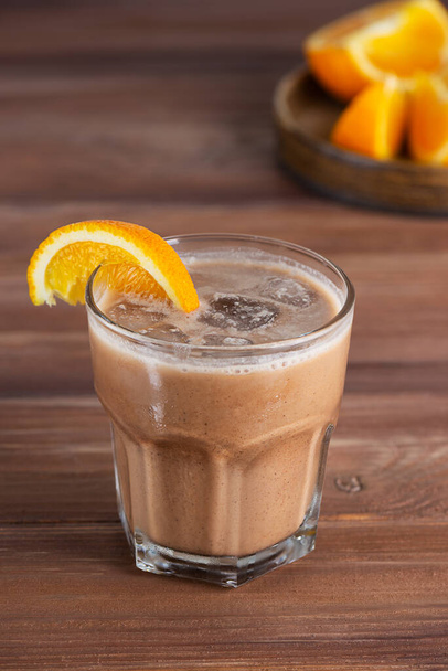 Café naranja moca con chocolate y leche de coco en un vaso sobre una mesa de madera. Sin azúcar, gluten ni lactosa. - Foto, imagen