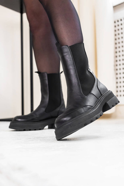 Black elegant winter boots, stylish leather lady footwear. Urban lifestyle, modern fashion concept photo - Photo, Image