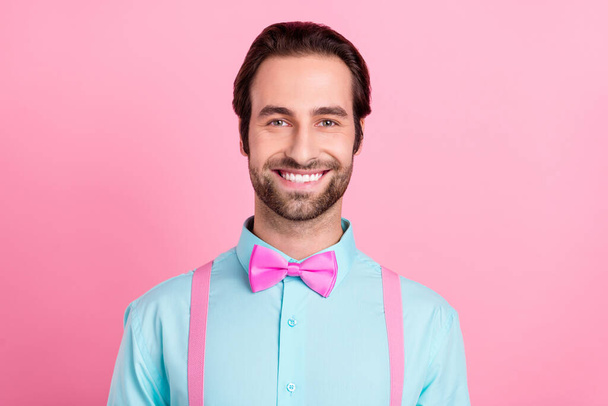 Foto de guapo guapo chico joven vestido verde azulado ropa sonriente aislado color rosa fondo - Foto, imagen