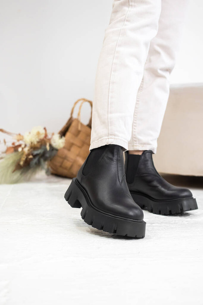 Close-up black winter shoes. Women's leather boots in studio. Casual style, lifestyle fashion concept - Photo, Image